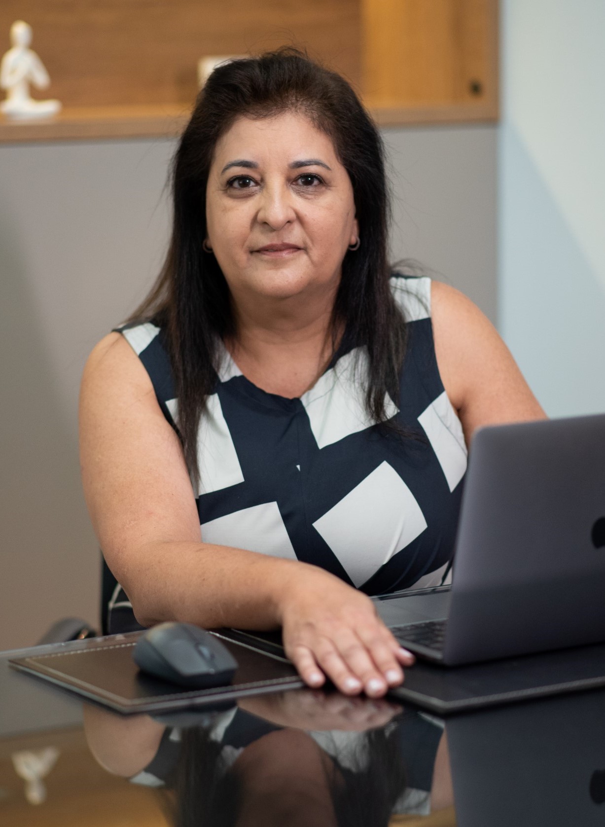 Dra. Renata sentada em uma mesa com um notebook.